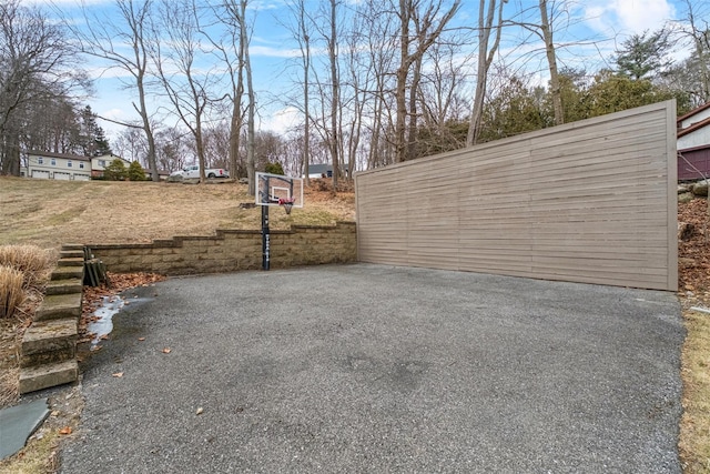 view of patio with basketball hoop and driveway