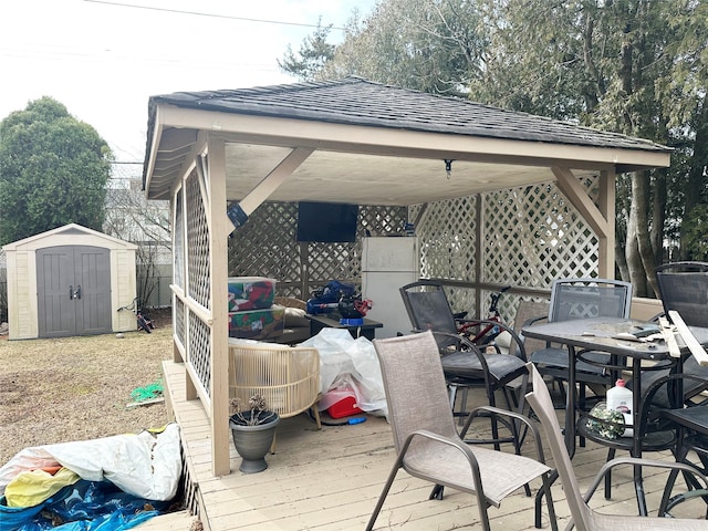 deck with an outbuilding, outdoor dining area, and a storage unit