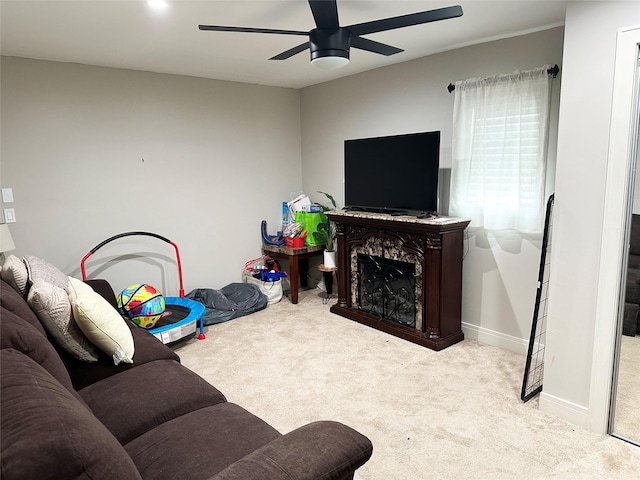 living area with a ceiling fan, carpet, and baseboards