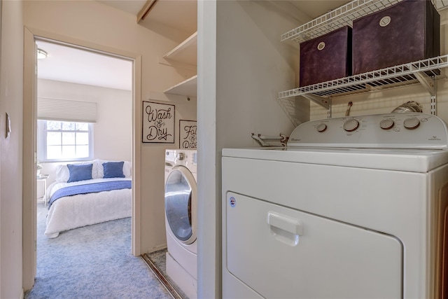 washroom with carpet floors, washing machine and dryer, and laundry area