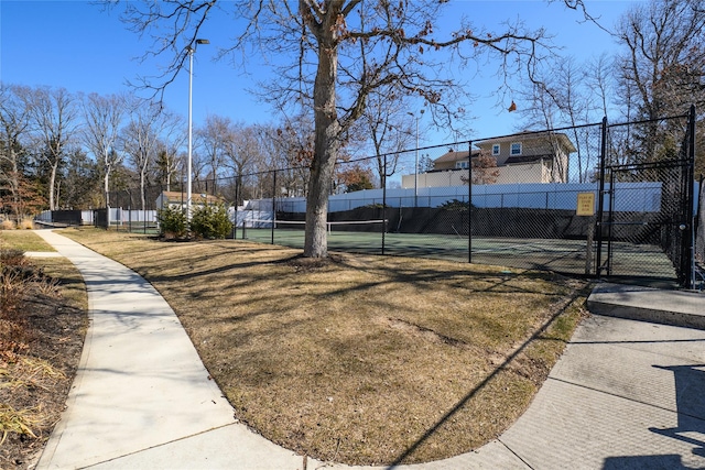 view of tennis court with a gate and fence