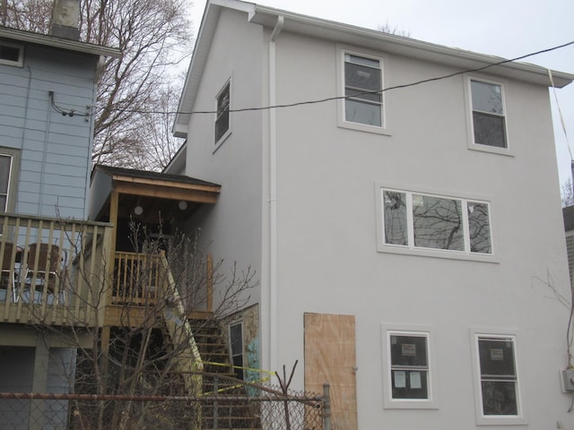 back of house with fence and stucco siding