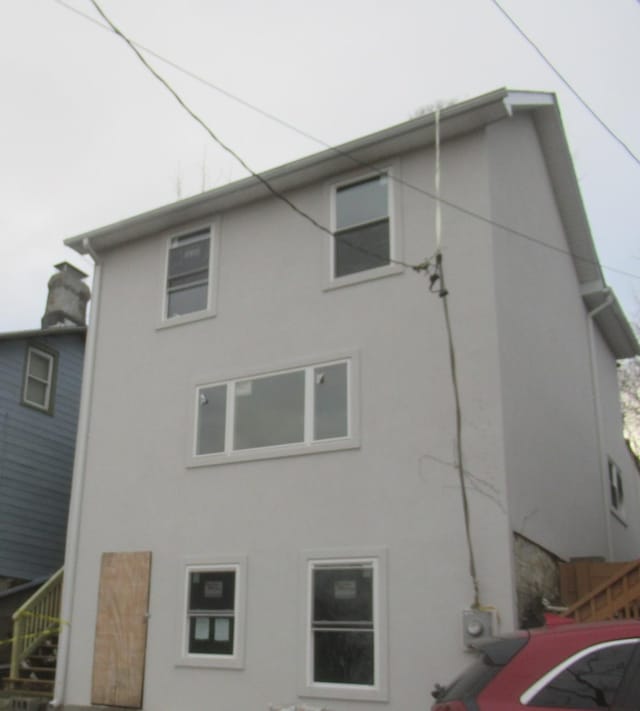 rear view of property featuring stucco siding