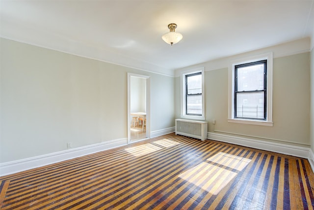 spare room with carpet, radiator heating unit, and baseboards