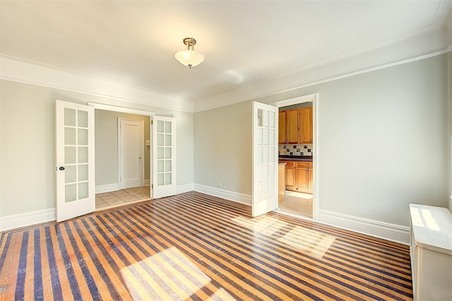 empty room featuring baseboards, light colored carpet, and french doors