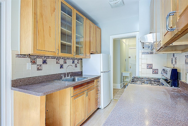 kitchen featuring dark countertops, stainless steel range oven, a sink, and decorative backsplash