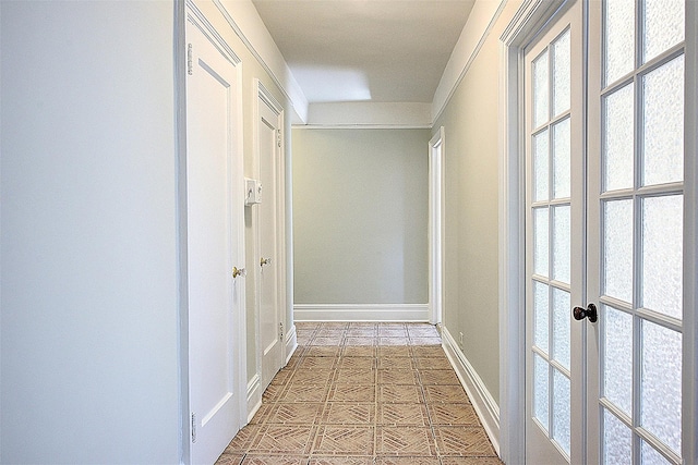 hallway featuring baseboards, a wealth of natural light, and french doors