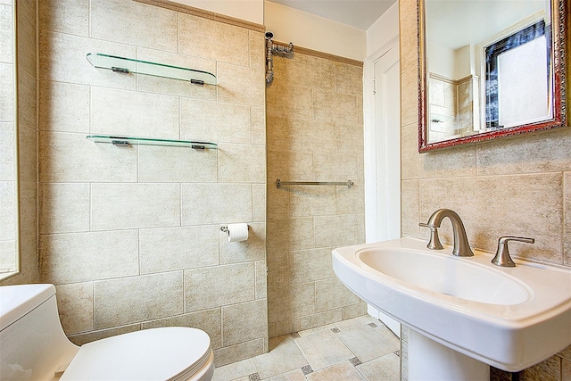 half bath with tile walls, toilet, and a sink