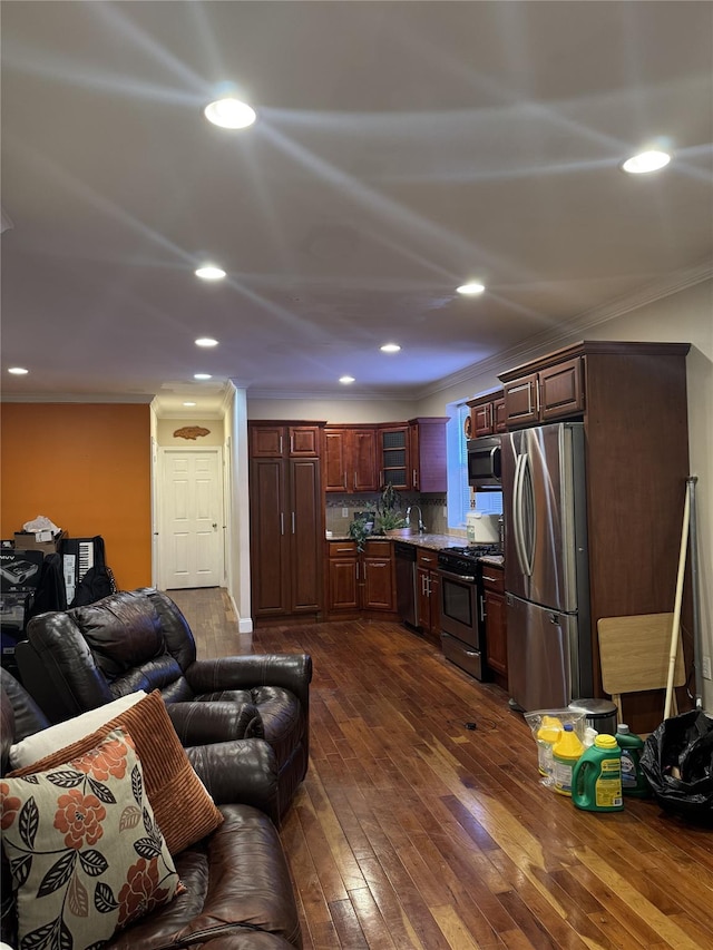 kitchen with open floor plan, stainless steel appliances, dark wood finished floors, and crown molding