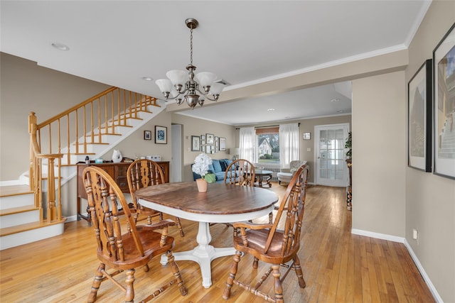 dining room with ornamental molding, stairway, light wood finished floors, baseboards, and a chandelier