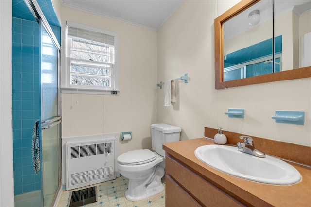 bathroom with vanity, heating unit, a shower stall, crown molding, and toilet