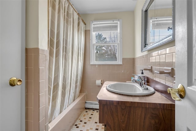 bathroom with shower / bath combo with shower curtain, baseboard heating, tile walls, and vanity