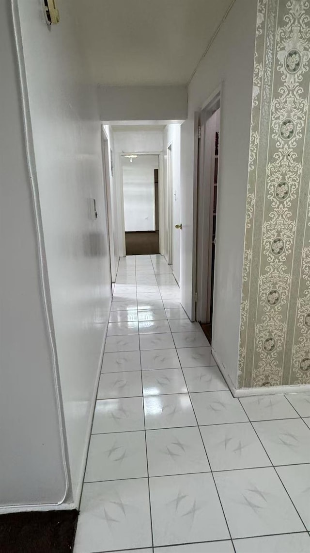 hallway with baseboards and marble finish floor