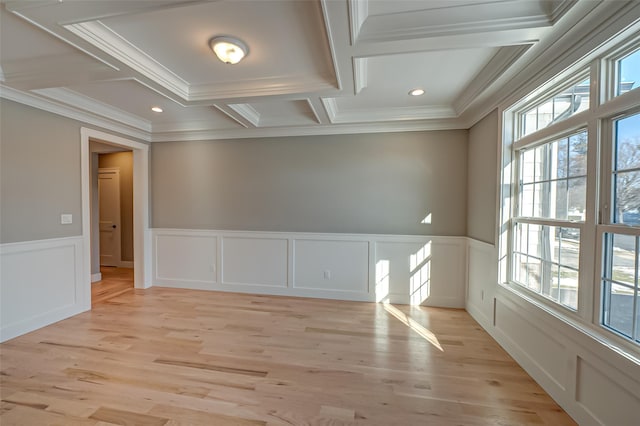 spare room with light wood-style flooring, ornamental molding, coffered ceiling, and wainscoting