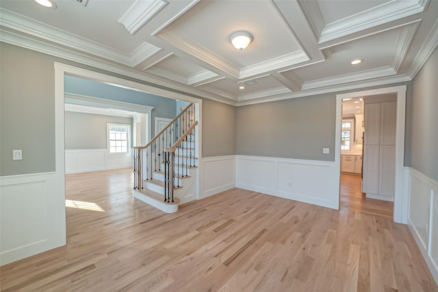 spare room with a wainscoted wall, stairs, coffered ceiling, and light wood-style floors