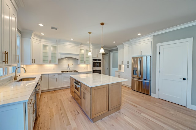 kitchen with tasteful backsplash, visible vents, appliances with stainless steel finishes, light wood-style floors, and a sink