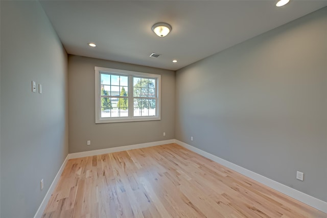 spare room featuring light wood-style floors, recessed lighting, and baseboards