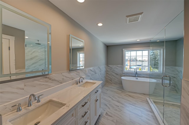 bathroom with a wealth of natural light, a sink, and a marble finish shower