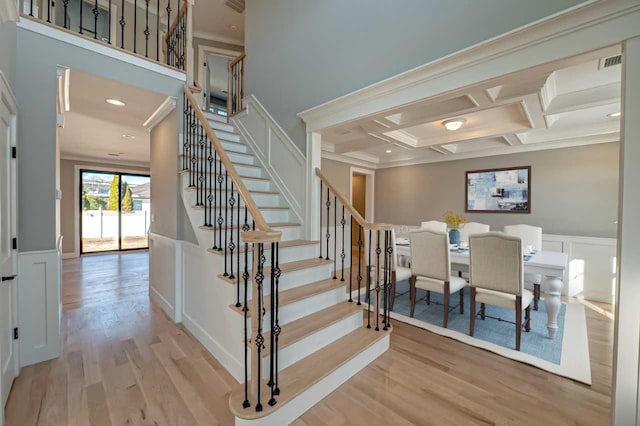1012 Olympia Rd, Bellmore, NY 11710 - staircase with ornamental molding, wood finished floors, coffered ceiling, a wainscoted wall, and a decorative wall
