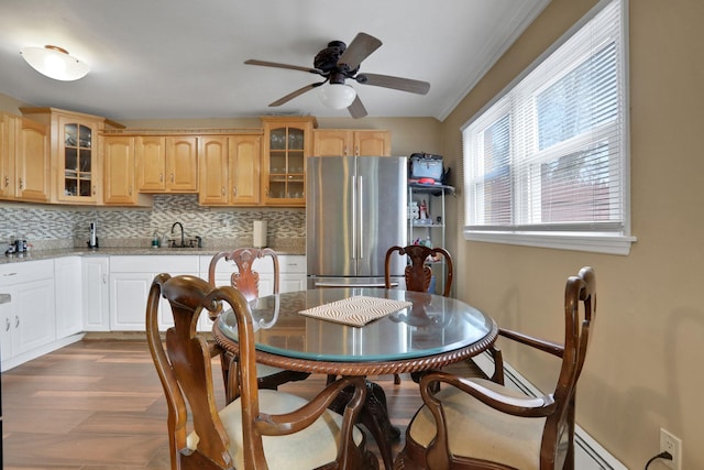 dining room featuring dark wood-style floors, a baseboard heating unit, and a ceiling fan