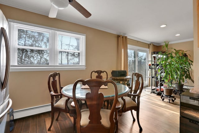 dining room featuring light wood-type flooring, ceiling fan, ornamental molding, and baseboard heating