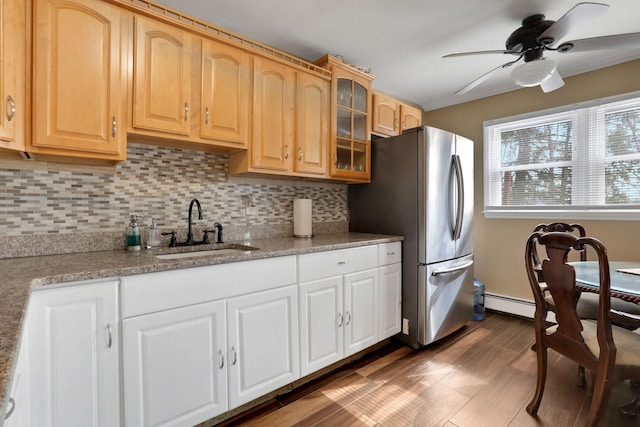 kitchen featuring tasteful backsplash, ceiling fan, glass insert cabinets, freestanding refrigerator, and a sink