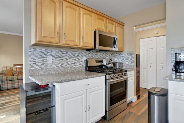 kitchen with stainless steel appliances, beverage cooler, light brown cabinets, and crown molding