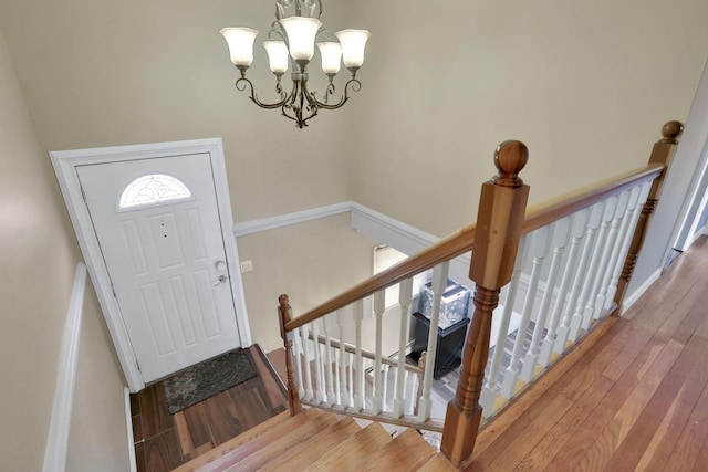 entrance foyer with a chandelier and wood finished floors