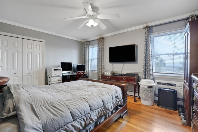 bedroom with a baseboard radiator, a closet, crown molding, and light wood finished floors