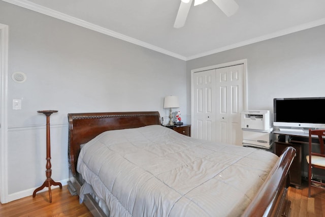 bedroom featuring ceiling fan, ornamental molding, a closet, and wood finished floors