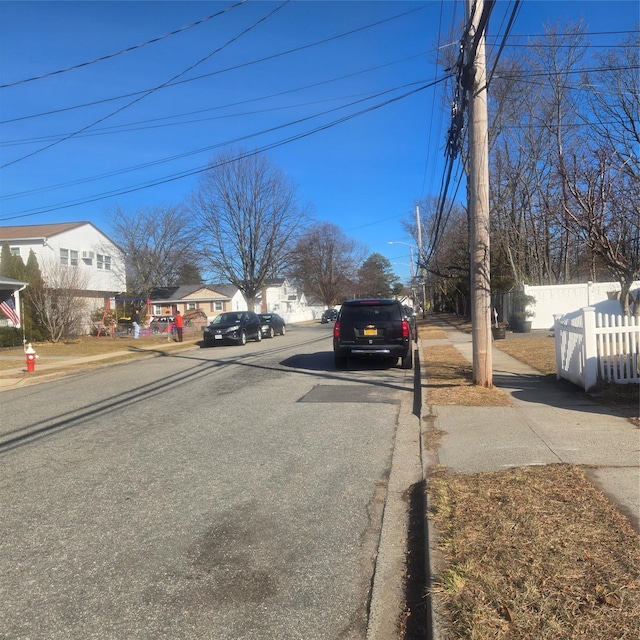 view of street featuring a residential view, curbs, and sidewalks