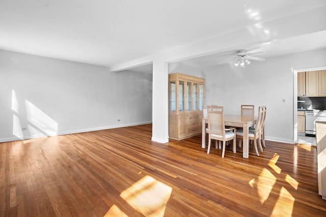 unfurnished dining area featuring a ceiling fan, wood finished floors, and baseboards