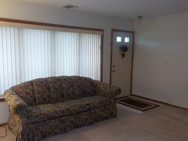 living area with light carpet and visible vents