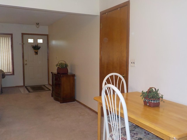 dining room featuring baseboards and light colored carpet