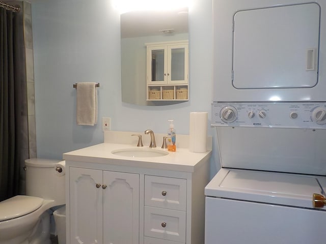 full bathroom with toilet, stacked washing maching and dryer, and vanity