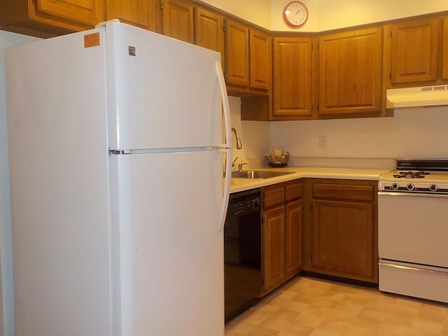 kitchen with light floors, light countertops, brown cabinetry, white appliances, and under cabinet range hood