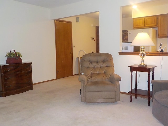 sitting room featuring light colored carpet, visible vents, and baseboards