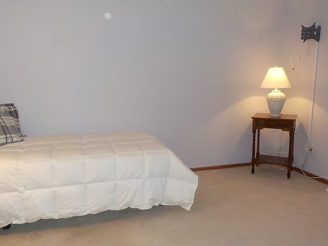 bedroom featuring light carpet and baseboards