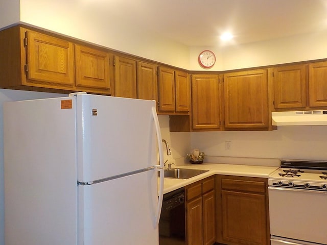 kitchen featuring under cabinet range hood, white appliances, a sink, light countertops, and brown cabinetry