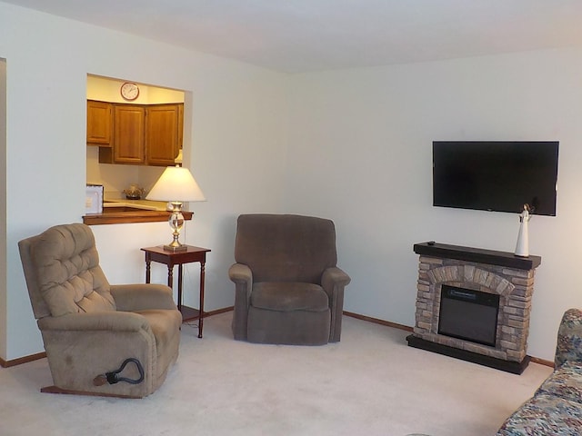 living area with light colored carpet, a stone fireplace, and baseboards