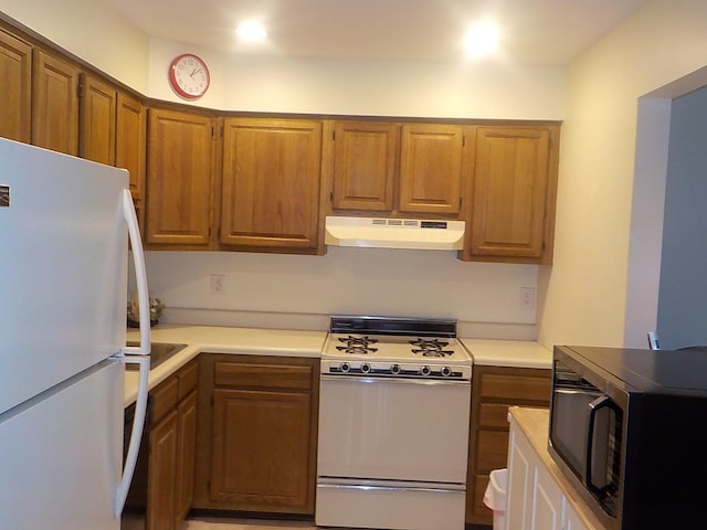 kitchen with brown cabinetry, white appliances, light countertops, and under cabinet range hood