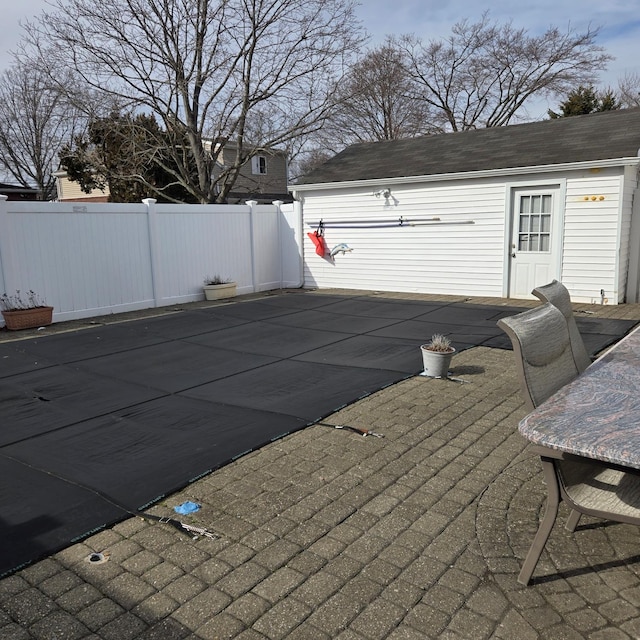 view of pool with fence and an outbuilding