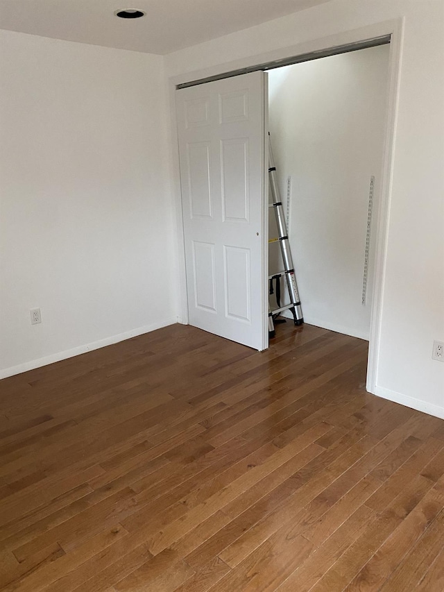 interior space featuring wood-type flooring and baseboards