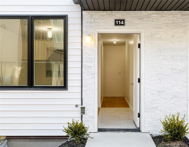 view of exterior entry featuring brick siding