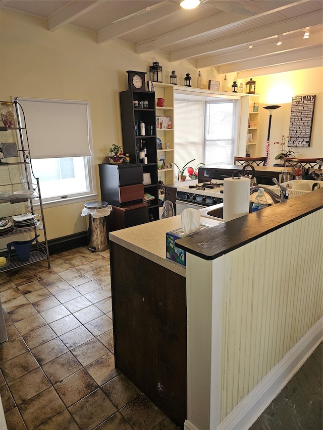 kitchen featuring tile patterned flooring, beam ceiling, baseboards, and open shelves