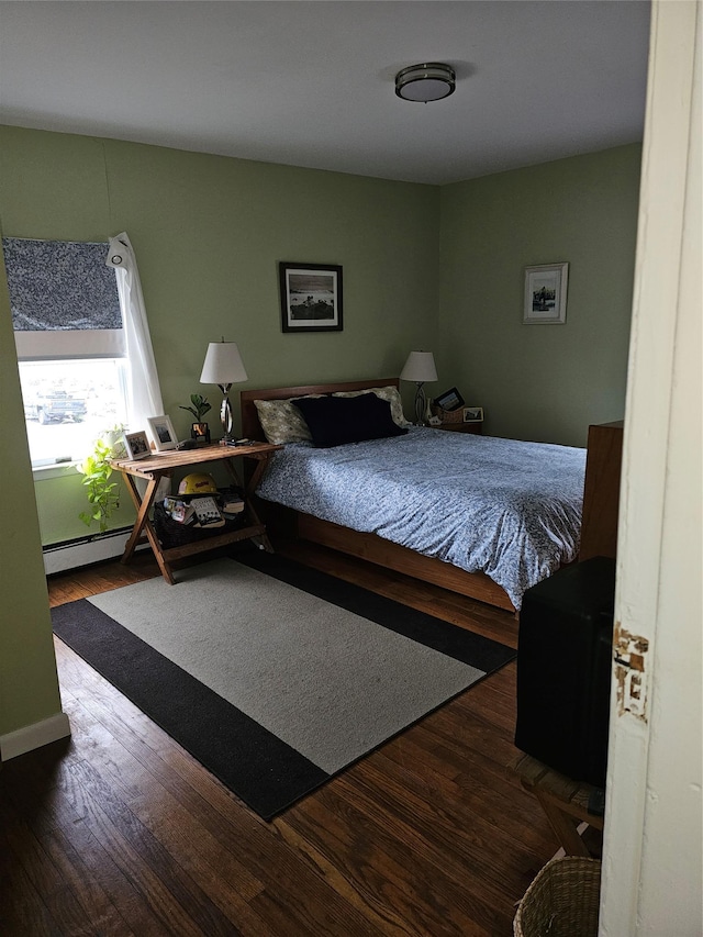 bedroom with a baseboard radiator and wood finished floors