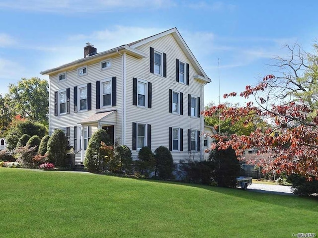 view of front of house with a chimney and a front yard