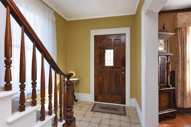 entryway with crown molding, stairway, baseboards, and tile patterned floors