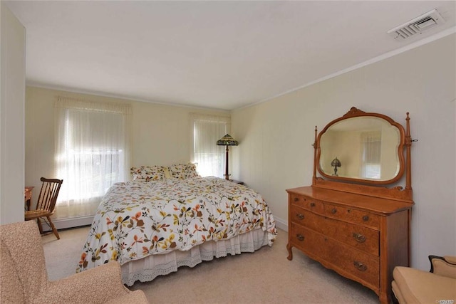 carpeted bedroom featuring ornamental molding and visible vents