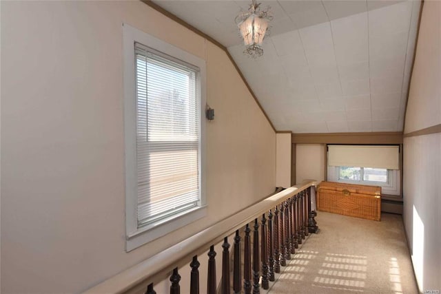 hallway with lofted ceiling and light colored carpet